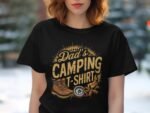 A woman wearing a black t-shirt featuring the text "Dad's Camping T-Shirt" with camping graphics in a blurred outdoor background.