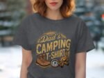 A woman wears a dark gray t-shirt featuring "Dad's Camping T-Shirt" text with camping boots, a compass, and a campfire graphic.