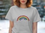 A woman wearing a light gray t-shirt displays a colorful rainbow graphic with mountains and the text "I’d hike that."