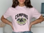 Woman wearing a pink t-shirt with "CAMPING" and a graphic of a tent and trees. Light background with soft décor.