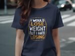A woman in a navy t-shirt with the text "I would lose weight but I hate losing" printed on it, standing outdoors.