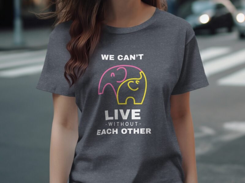 A woman wearing a dark gray t-shirt with colorful elephant graphics and the text "We can't live without each other."