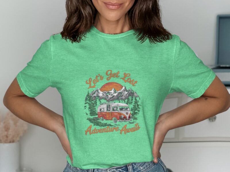 Woman wearing a green t-shirt with "Let's Get Lost Adventure Awaits" graphic featuring mountains and a vintage van.