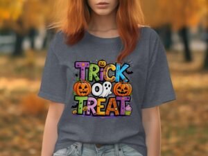 Young woman wearing a gray t-shirt with colorful "Trick or Treat" graphic, surrounded by autumn trees.