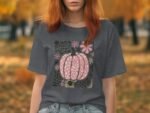 Model wearing a gray t-shirt featuring a floral pumpkin design, set against a softly blurred autumn background.