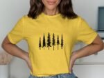 A woman wearing a yellow t-shirt with a black tree graphic, posing with her hands on her hips.