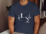 A man fishing on a heartbeat line, with a leaping fish and water splashes, depicted on a blue t-shirt.