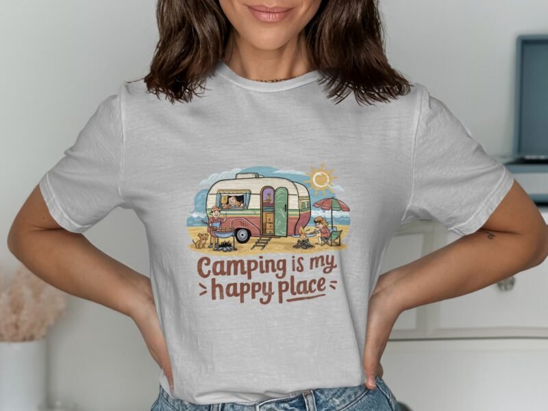 A woman wearing a light gray t-shirt with a colorful camping graphic reading "Camping is my happy place."