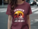 A woman in a maroon t-shirt with a summer-themed graphic featuring sunglasses, palm trees, and a sunset.
