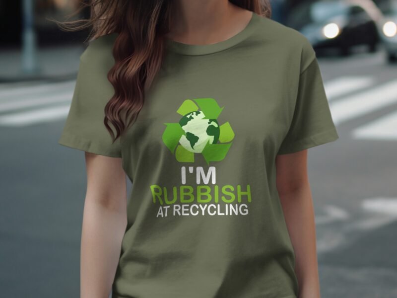 A person wearing an olive green t-shirt with a recycling logo and the text "I'M RUBBISH AT RECYCLING."