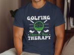 Man wearing a navy blue t-shirt with a golf ball graphic and the text "Golfing Cheaper Than Therapy."
