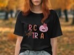 A woman with red hair wearing a black t-shirt featuring "TRICK OR TREAT" with a pumpkin and spider web design.