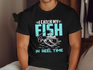 A person wearing a black t-shirt featuring the phrase "I CATCH MY FISH IN REEL TIME" with fishing graphics.