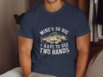 Man wearing a navy blue t-shirt with a graphic of a large fish and text: "MINE'S SO BIG I HAVE TO USE TWO HANDS."