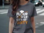 A woman wearing a gray t-shirt with the text "Flour Power - Let's Get Dirty" displayed prominently.