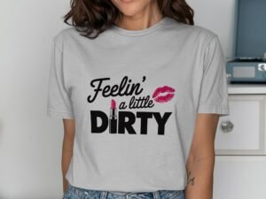 A woman in a gray t-shirt with the text "Feelin' a little DIRTY" and a pink lipstick graphic, smiling at the camera.