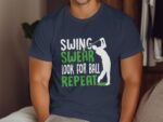 A person wearing a navy t-shirt with the text "SWING SWEAR LOOK FOR BALL REPEAT" and a golfer silhouette.