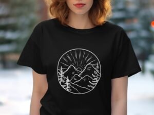 A woman with wavy hair wears a black t-shirt featuring a mountain illustration with trees and rays of sunlight.