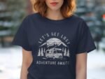 A woman wears a navy t-shirt featuring a camping design with mountains and a camper van, text reads "Let's Get Lost Adventure Awaits."