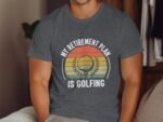 Man wearing a gray T-shirt with the text "My Retirement Plan Is Golfing" and a graphic of a golf ball and greenery.