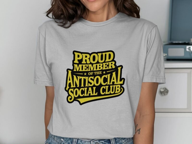 A woman wearing a light gray t-shirt with the text "PROUD MEMBER OF THE ANTISOCIAL SOCIAL CLUB" in bold yellow letters.