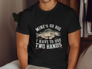 A person in a black t-shirt holding a large fish, with the text "Mine's so big I have to use two hands."