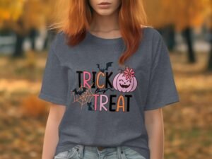 Woman wearing a gray t-shirt with "TRICK or TREAT" graphic, surrounded by autumn foliage.