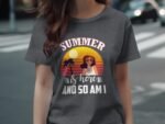 A woman wearing a gray t-shirt with a colorful summer graphic featuring a sun, palm trees, and text.
