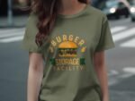 A person wearing an olive green t-shirt featuring "BURGER STORAGE FACILITY" and an illustrated burger graphic.