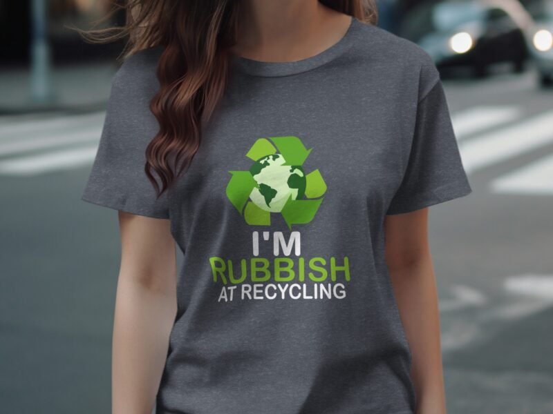 A person wearing a gray t-shirt with a recycling graphic and the text "I'M RUBBISH AT RECYCLING" in bold letters.