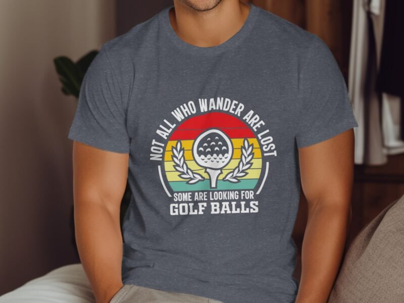 Man wearing a gray t-shirt with a humorous golf-themed graphic and text about wandering and seeking golf balls.