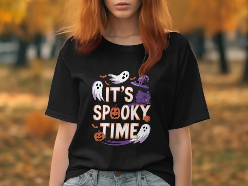 A person wearing a black t-shirt with "It's Spooky Time" text, ghosts, a pumpkin, and a haunted house design.