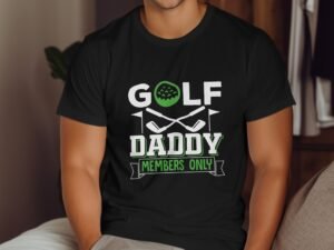 A person wearing a black t-shirt with "GOLF DADDY MEMBERS ONLY" text and golf graphics, sitting indoors.