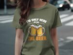 A person wearing an olive green t-shirt with the text "I'm only here for THE BEER" and two beer mugs graphic.