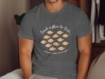 A person wearing a gray t-shirt with the text "Teach a Man to Fish..." and illustrations of orange fish.