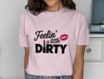 A woman wearing a light pink t-shirt with the text "Feelin' a little DIRTY" and a lipstick graphic.