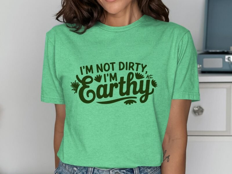 A woman in a green t-shirt with the text "I'm Not Dirty, I'm Earthy" stands against a light background.