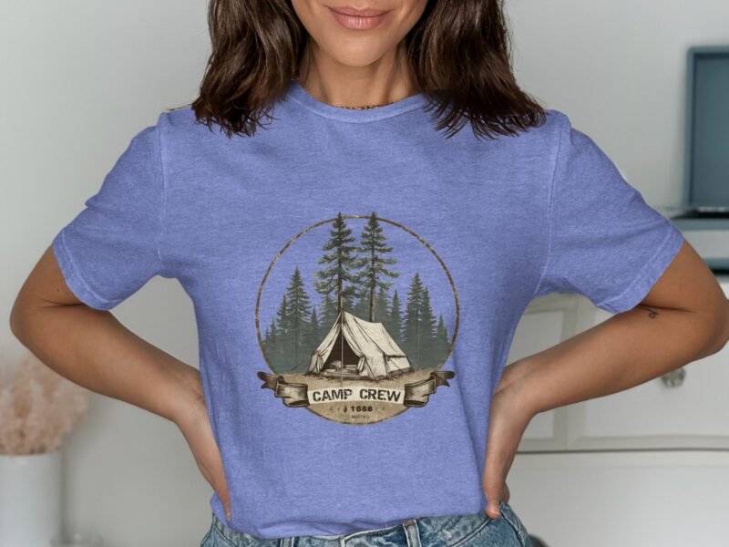 Woman wearing a light blue t-shirt with a "Camp Crew" graphic featuring a tent and pine trees.