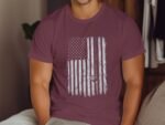 Man wearing a maroon T-shirt featuring a distressed American flag graphic on the front.