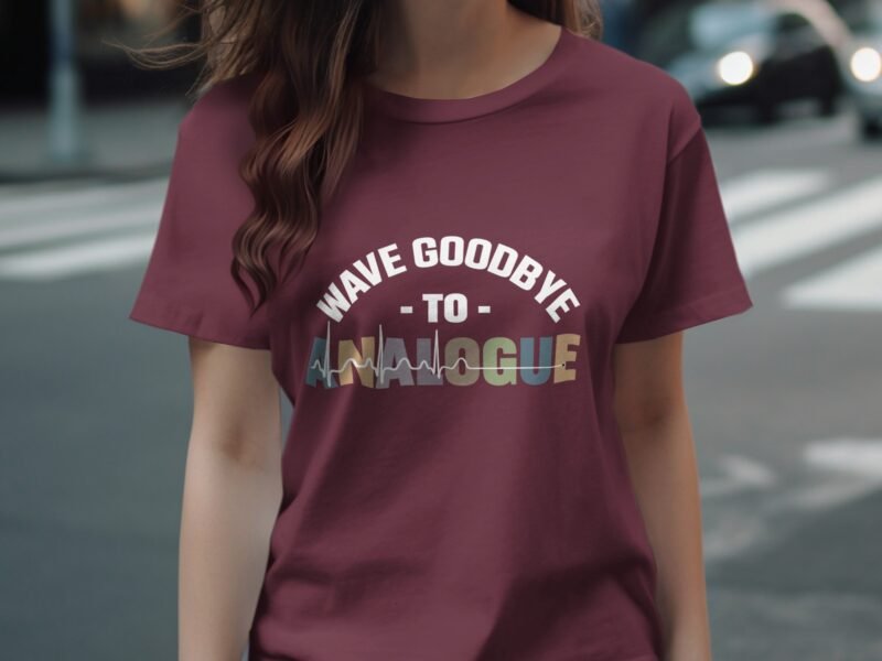 A person wearing a maroon t-shirt with the text "WAVE GOODBYE TO ANALOGUE" in bold, colorful lettering.