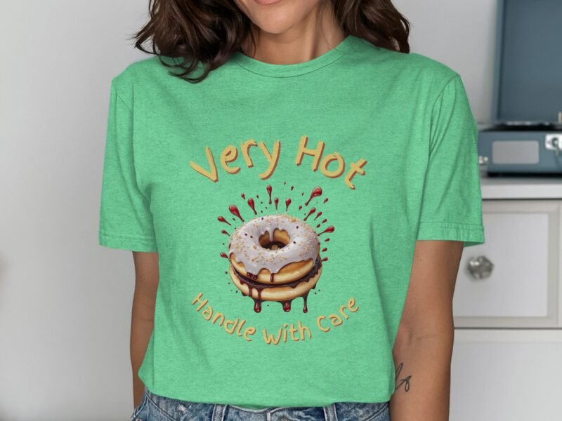 Woman wearing a green t-shirt featuring a cartoon donut and the text "Very Hot, Handle With Care."