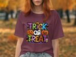 A person with red hair wears a maroon t-shirt featuring a colorful "Trick or Treat" design with pumpkins and a ghost.