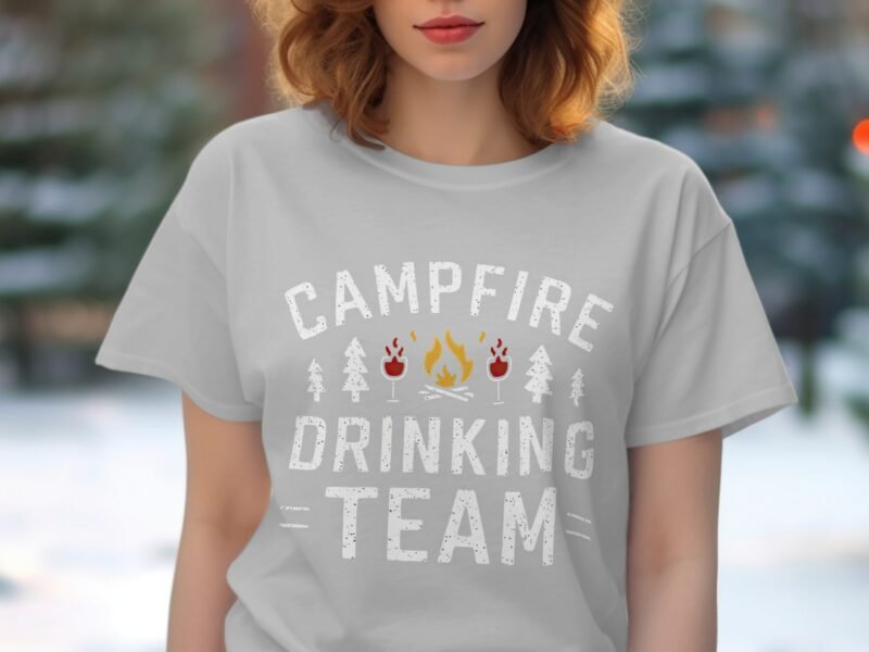 Woman wearing a gray t-shirt with the text "CAMPFIRE DRINKING TEAM" surrounded by fire and tree graphics.