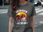 Woman wearing a gray t-shirt with a colorful summer graphic featuring sunglasses, a sunset, and palm trees.