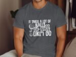 Man wearing a dark gray t-shirt with the text "It takes a lot of balls to golf like I do" and two golf ball illustrations.