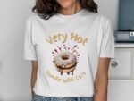 Woman in a white t-shirt featuring a donut graphic with the text "Very Hot" and "Handle With Care" above it.