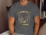 A man wearing a gray "Gone Fishin'" t-shirt sits casually, with a fishing graphic featuring a fisherman in a boat.
