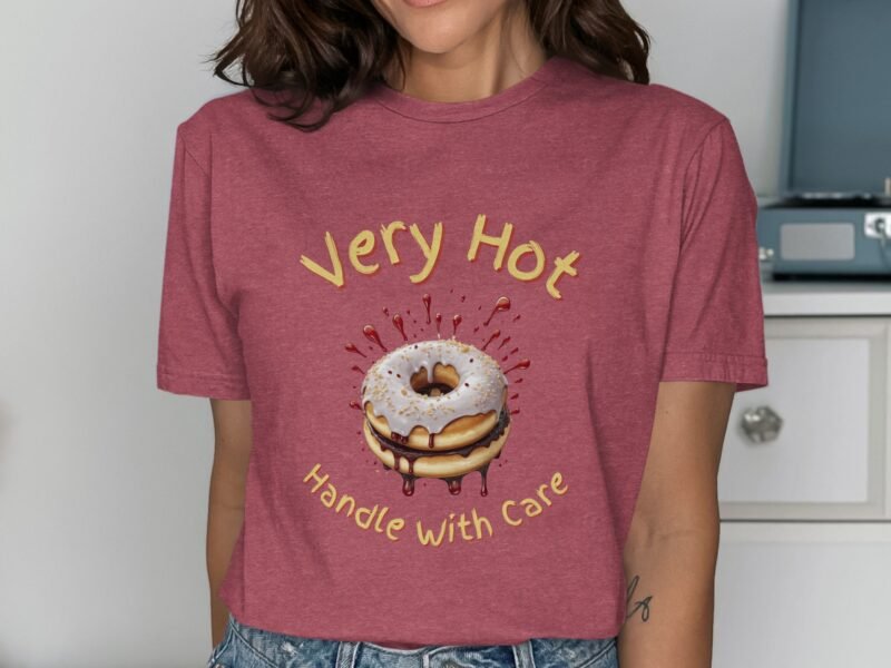 A woman wearing a maroon shirt with a donut graphic and text "Very Hot Handle with Care" in yellow.