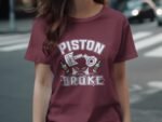 A woman wears a maroon t-shirt featuring the text "PISTON BROKE" and bottle graphics, standing on a street.