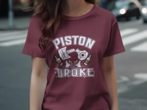 A woman wears a maroon t-shirt featuring the text "PISTON BROKE" and bottle graphics, standing on a street.